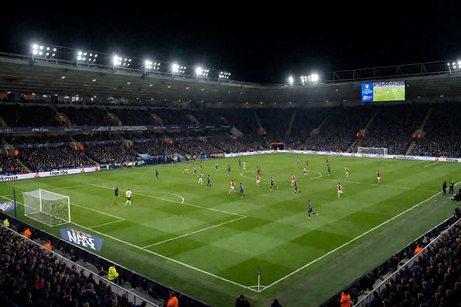 夜晚体育场内灯光下的足球比赛现场全景